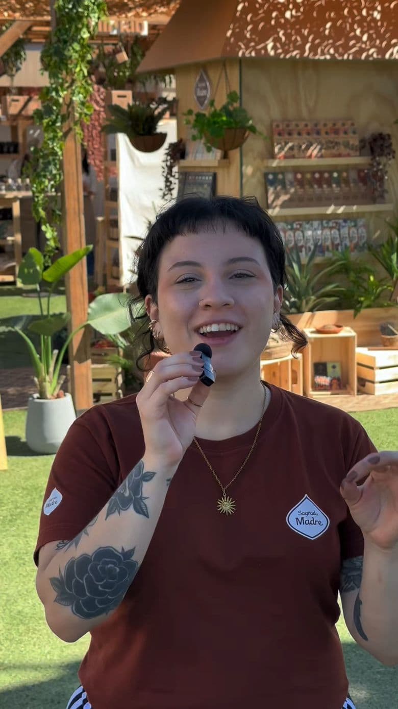 Cobertura en un stand de Sagrada Madre: promotora sonriendo con un producto en la mano