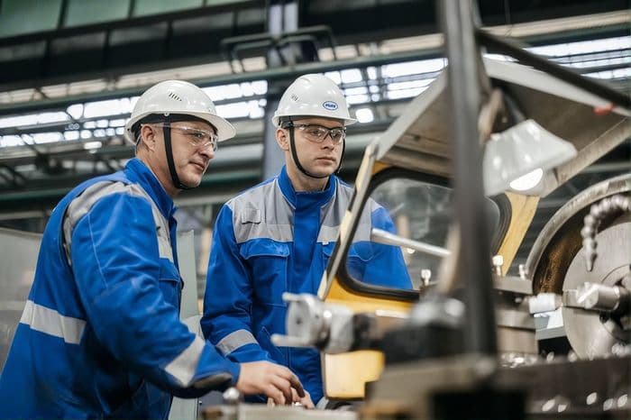 Operario con casco trabajando en una máquina industrial