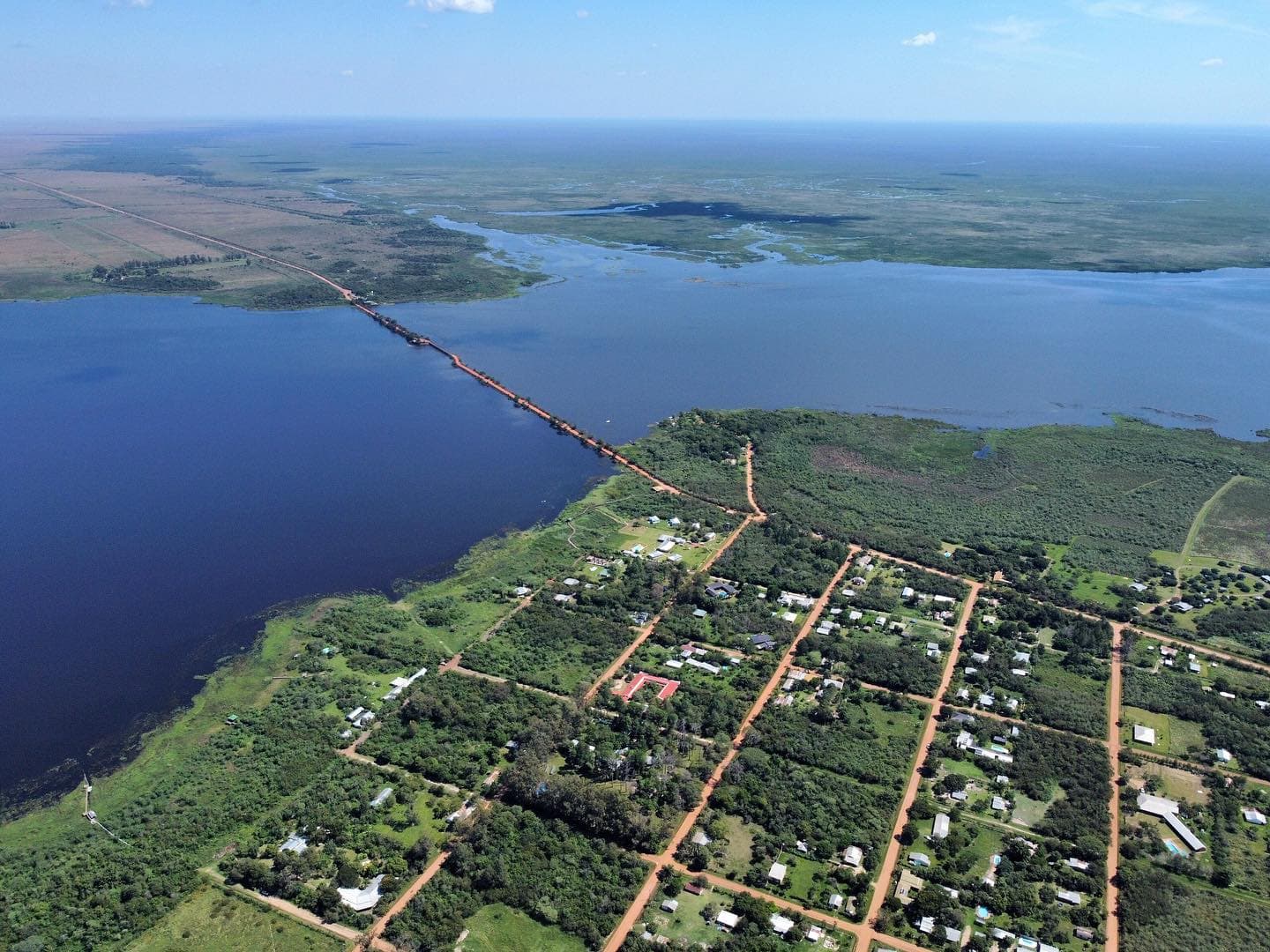 Vista aérea de Colonia Carlos Pellegrini junto a la laguna Iberá, con la calzada que cruza el agua
