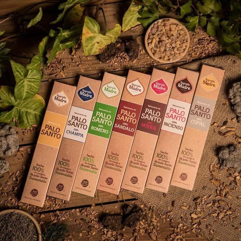 Cajas de sahumerios de palo santo Sagrada Madre en distintas variedades sobre una mesa de madera